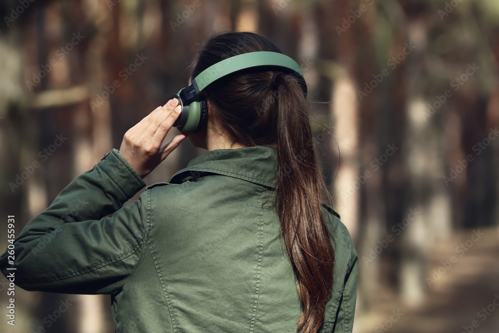 Young woman listening to music in forest