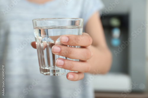 Woman with glass of water indoors, closeup