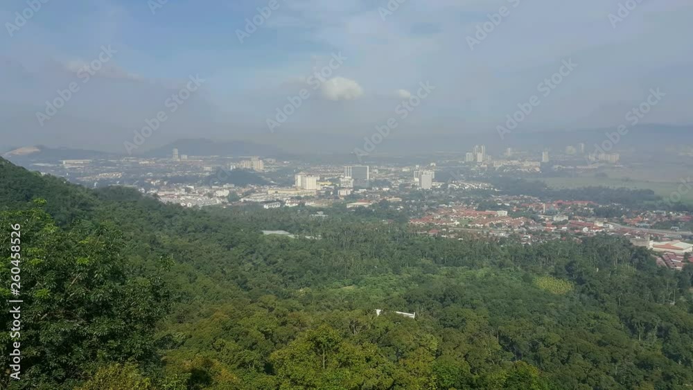Timelapse aerial view Bukit Mertajam town with green forest in foreground..