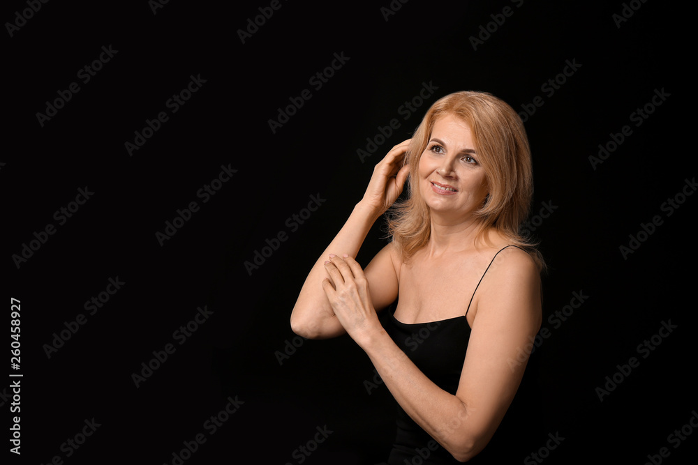 Stylish mature woman on dark background