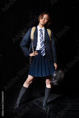 Asian Chinese girl dressed in school uniform cosplay PUBG character wearing school uniform, an iron halmet, and M16 toy gun. photo