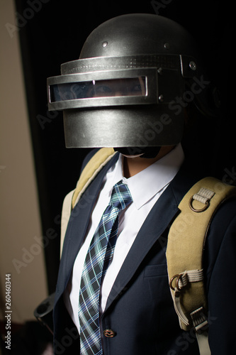 Asian Chinese girl dressed in school uniform cosplay PUBG character wearing school uniform, an iron halmet, and M16 toy gun.