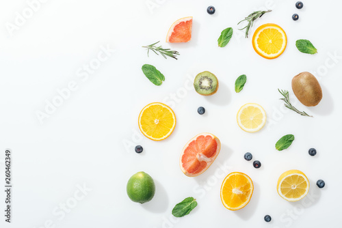 Top view of fresh fruits, rosemary and blueberries on white surface