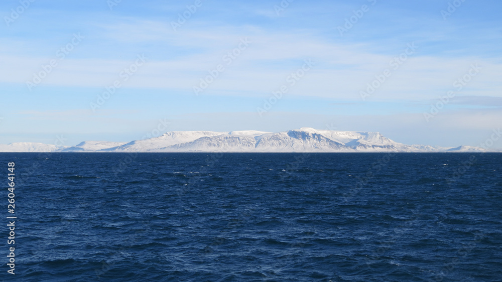 Atlantik um Reykjavik und schneebedeckte Hügel mit blauem Himmel