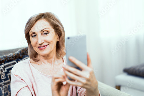 Beautiful mature woman takes selfie at home