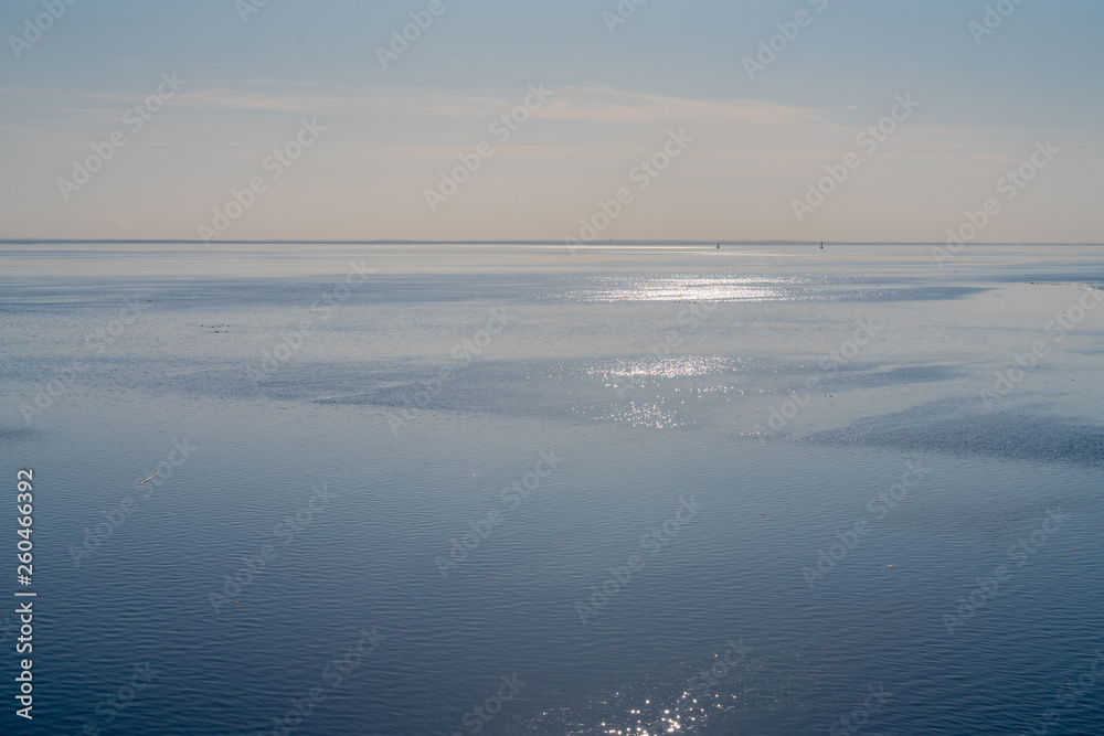 dramatic seascape calm sea in spring with broken pieces of ice on the surface