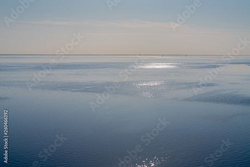 dramatic seascape calm sea in spring with broken pieces of ice on the surface