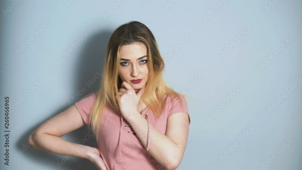 beautiful young girl confidently looking into the camera and flirting on a studio background, concept of female behavior and emotions beautiful young girl confidently looking into the camera and flirting on a studio background, concept of female behavior and emotions