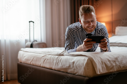 Businessman relaxing after meetings.  Manager resting after travelling. Man checking his wifi connection at a hotel room. © JustLife