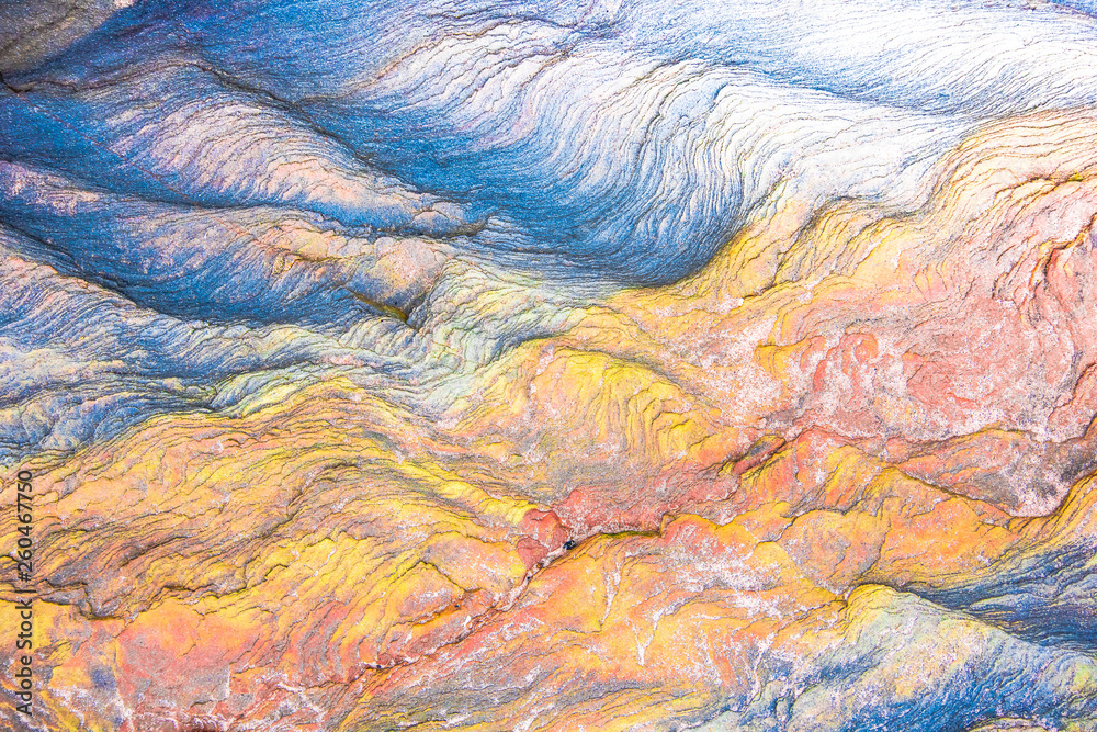 Colourful mosaics or rocks - layered sedimentary minerals exposed by sea - textured background