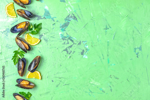 Seafood mussels with lemon and parsley on green concrete table surface