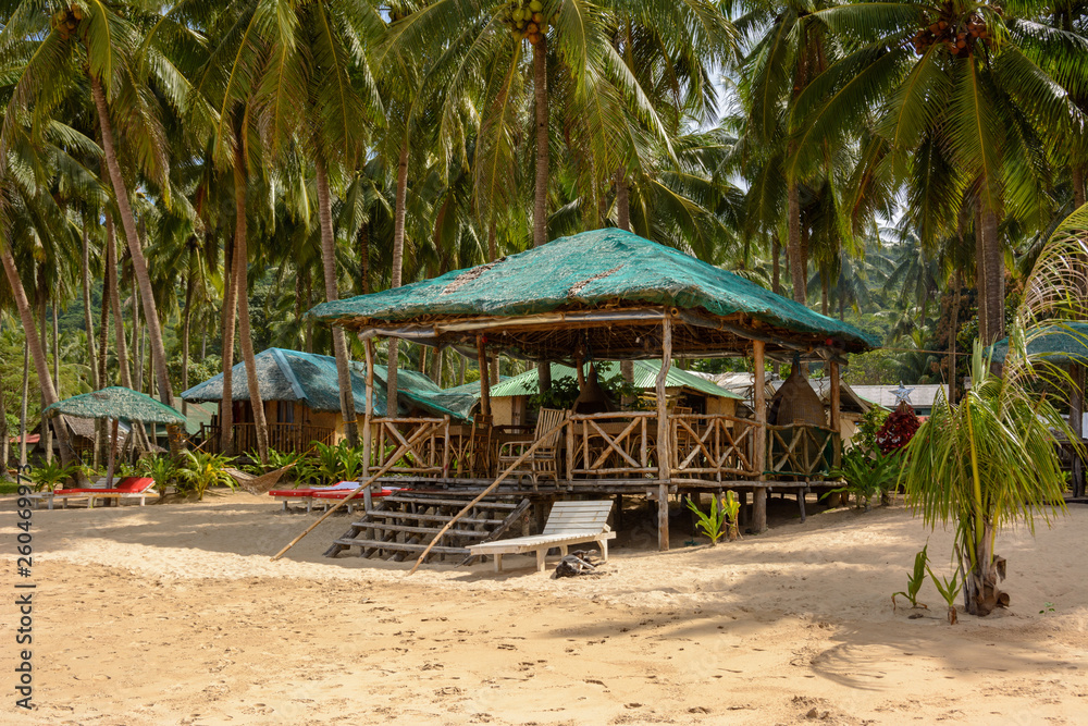 El Nido Beach, Philippines - wooden lounge area on a sandy beach