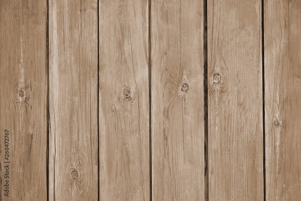 A fence from the tightly nailed wooden planks. Natural color of pine wood covered with transparent varnish. Sepia toned. Close-up. Selective focus. Copy space. A fence from the tightly nailed wooden planks. Natural color of pine wood covered with transparent varnish. Sepia toned. Close-up. Selective focus. Copy space.
