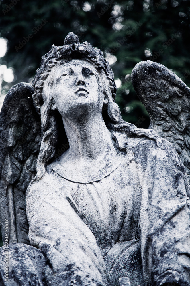 Antique stone statue of angel with sad expression that looks up. Antique stone statue of angel with sad expression that looks up.