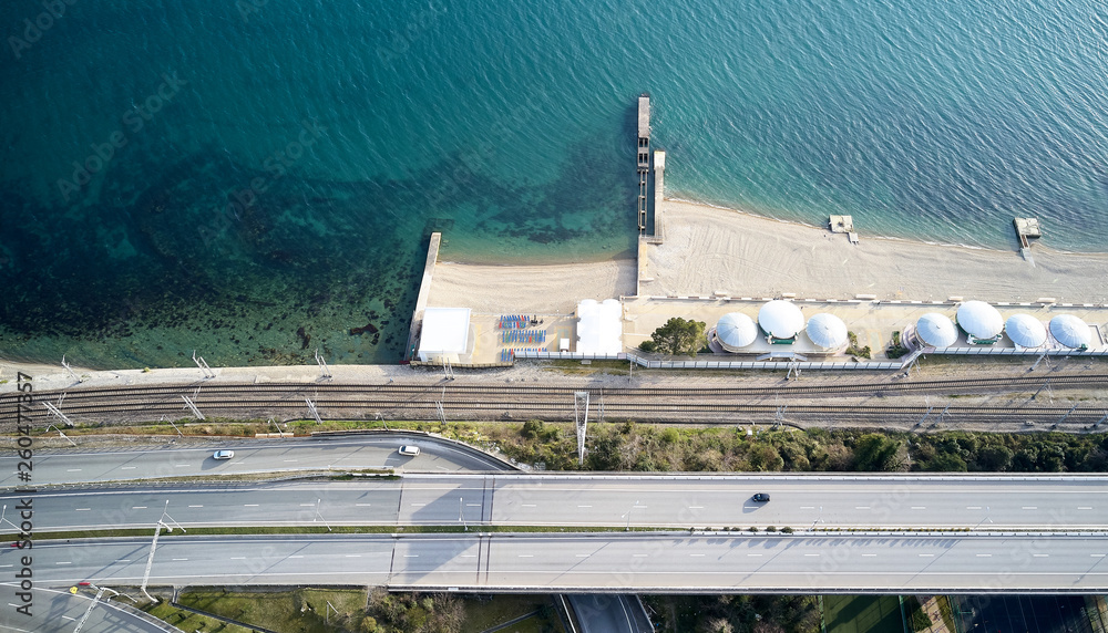 Seashore Beach of the black sea coast Pier in sea The road on which cars go along the beach. Umbrella from the sun on the beach. Bathing area No people. Clean beach. Aerial photography with quadcopter