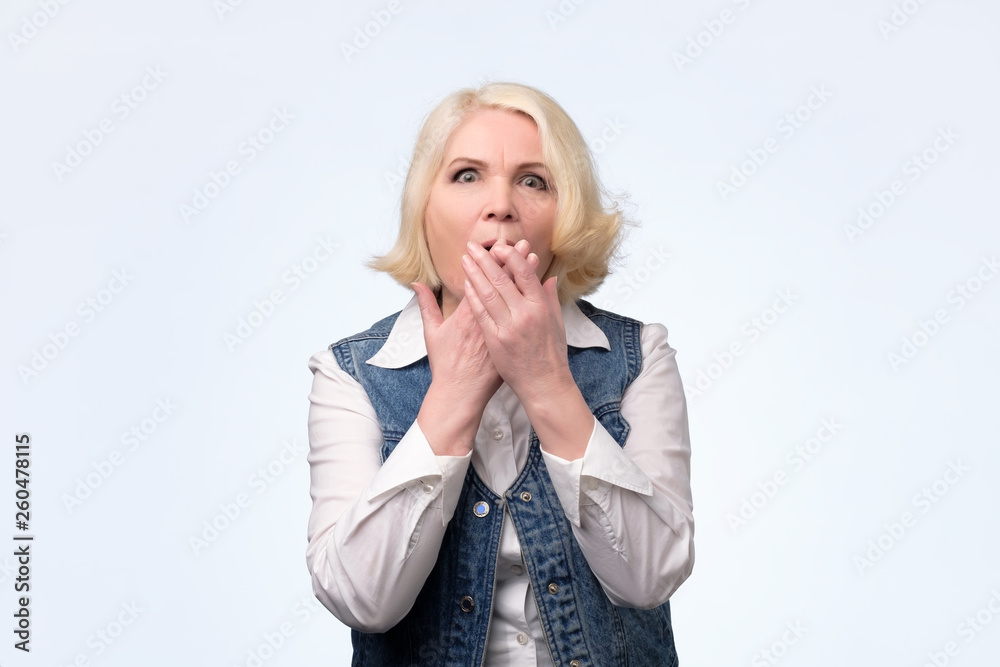 Blonde woman shocked covering mouth with hands. Blonde woman shocked covering mouth with hands.