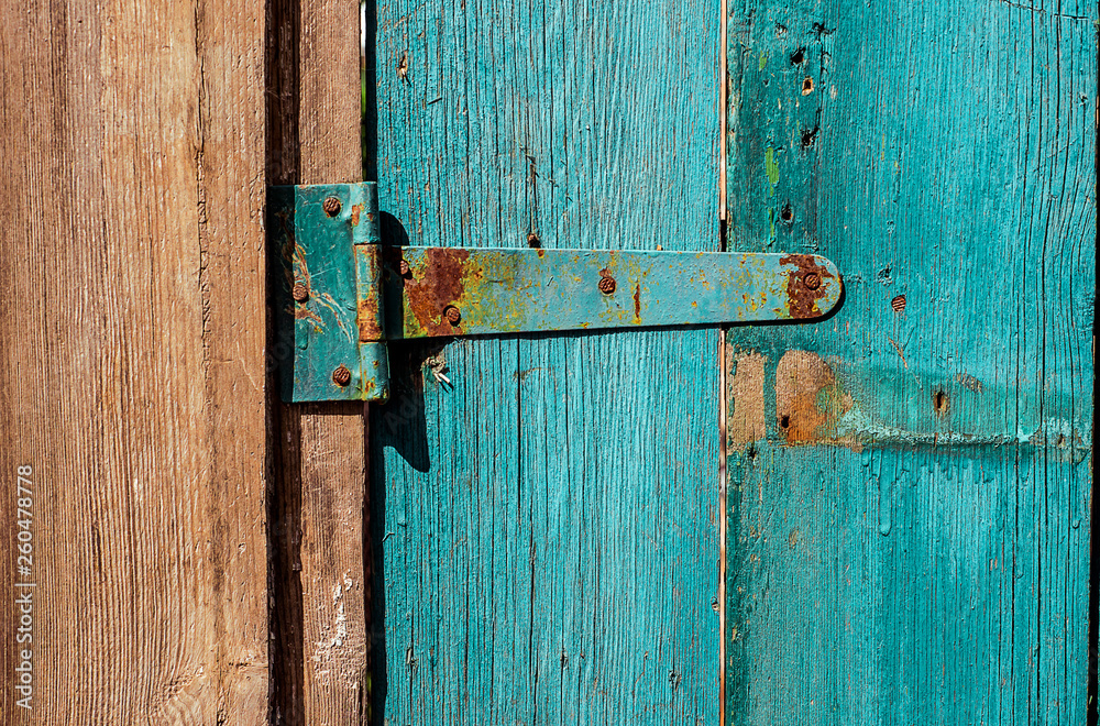Rusty Door hinge on blue painted wood door with cracked and scratch. Horizontal grunge texture Rusty Door hinge on blue painted wood door with cracked and scratch. Horizontal grunge texture