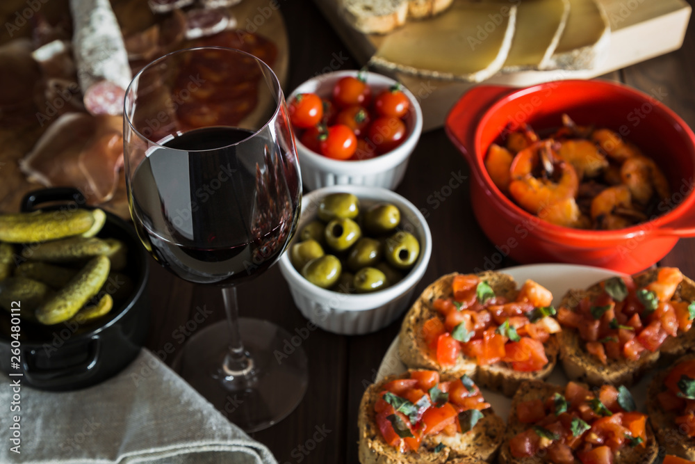 Red wine and tapas dishes on a wooden table