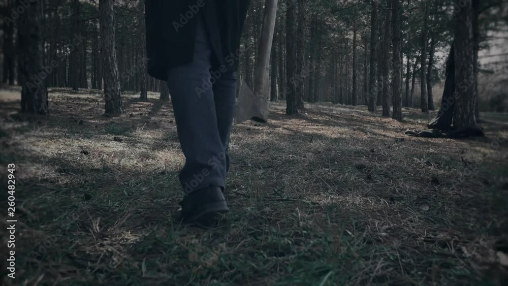 Serial killer goes swinging axe and chops down stump after crime in woods. Horror in park Serial killer goes swinging axe and chops down stump after crime in woods. Horror in park