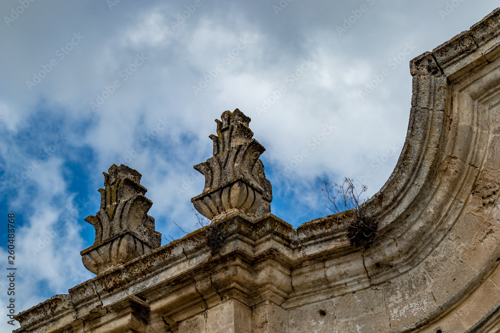 Rooftop decorations, architectural detail from the historic center of Matera, Italy, Basilcata region, low point of view from below, scenery summer day with puffy white clouds