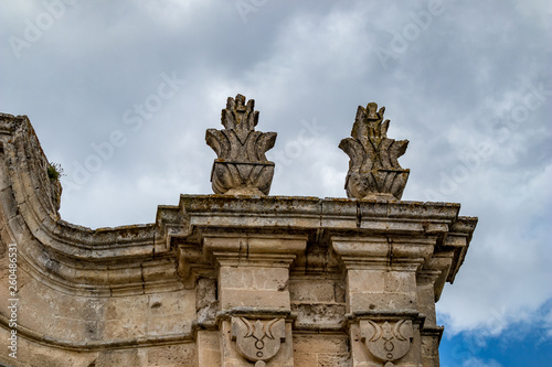 Rooftop decorations, architectural detail from the historic center of Matera, Italy, Basilcata region, low point of view from below, scenery summer day with puffy white clouds © lightcaptured
