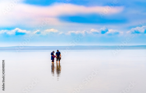 Fototapeta Naklejka Na Ścianę i Meble -  Silhouette of couple walking on the famous tourist destination Salt Lake (Turkish: Tuz Golu ) is the second largest lake in Turkey.