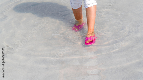 Woman wearing red or pink slipper walking on the famous tourist destination Salt Lake (Turkish: Tuz Golu) is the second largest lake in Turkey.