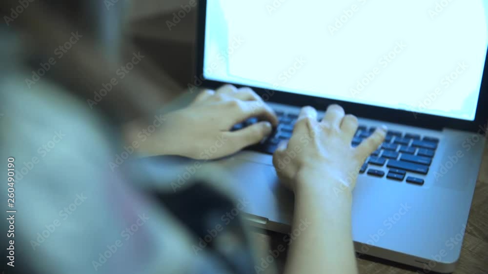 Young woman is working on a text document on her laptop. She is typing on the keyboard. Moving camera. Young woman is working on a text document on her laptop. She is typing on the keyboard. Moving camera.