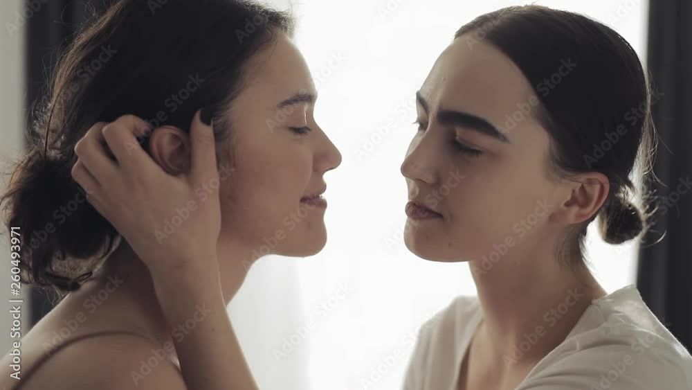 Happy lesbian couple embracing each other and smiling at home face to face in slow motion Happy lesbian couple embracing each other and smiling at home face to face in slow motion