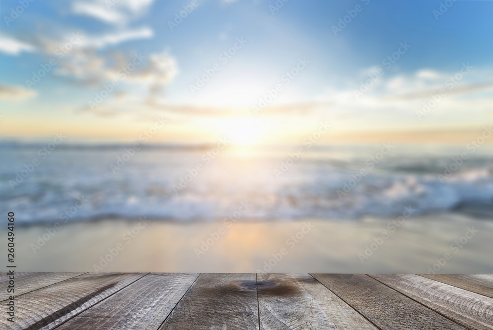Empty wooden table with blue sea and sand beach background.