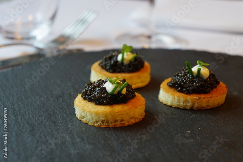 black caviar on a canape with sour cream