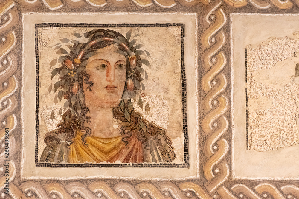 Ancient roman mosaic showing beautiful woman with flowers on her hair