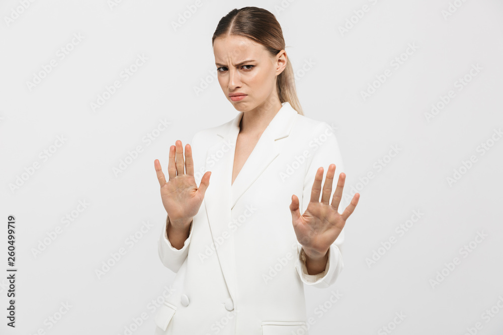 Beautiful displeased woman posing isolated over white wall background showing stop gesture. Beautiful displeased woman posing isolated over white wall background showing stop gesture.
