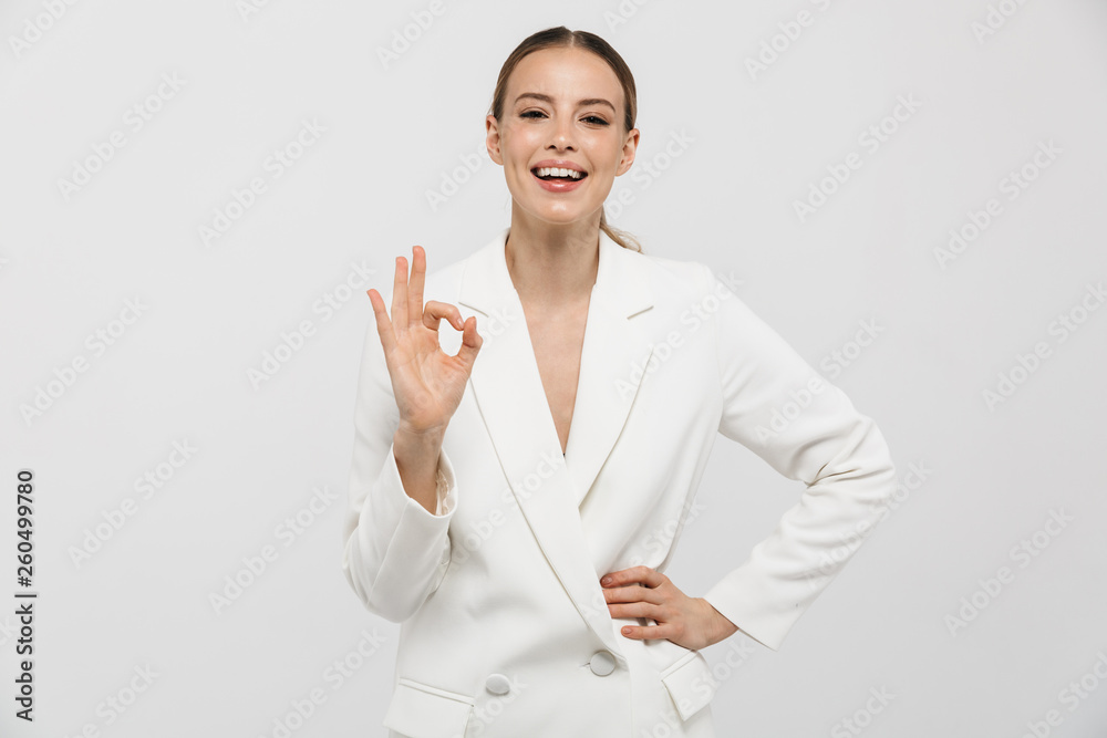 Beautiful happy woman posing isolated over white wall background showing okay gesture. Beautiful happy woman posing isolated over white wall background showing okay gesture.