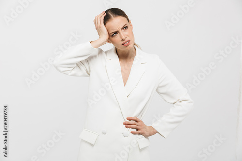 Beautiful displeased sad woman with headache posing isolated over white wall background.