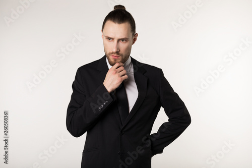 Handsome businessman wearing black suit and tie looking stressed and nervous with hand near face