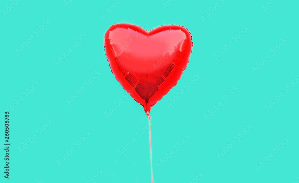 Colorful red heart shaped air balloon isolated on blue background