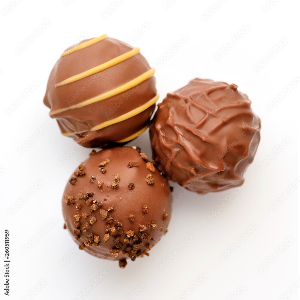 Three candies of milk chocolate on white background. Top view. Three candies of milk chocolate on white background. Top view.
