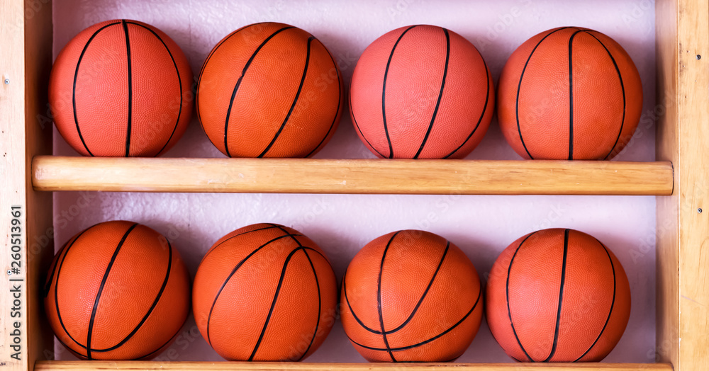 two rows of basketballs on the gym wooden stairs