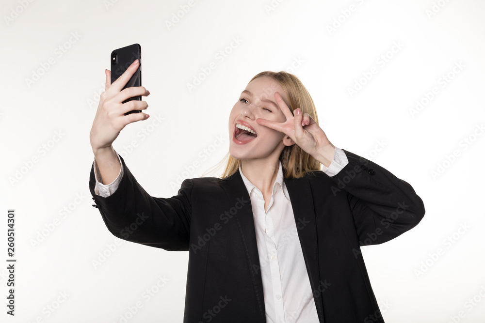 Waist up portrait of a smiling blonde businesswoman taking selfie with mobile phone Waist up portrait of a smiling blonde businesswoman taking selfie with mobile phone