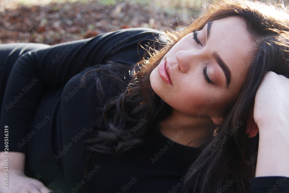 Beautiful caucasian model with long brown hairs laying on the ground Beautiful caucasian model with long brown hairs laying on the ground