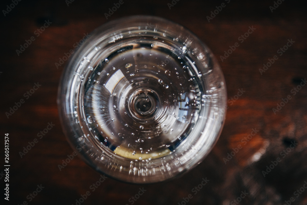 A glass of white wine on a rustic wooden red background. rest, holiday, party. crystal glass closeup. copy space. top view A glass of white wine on a rustic wooden red background. rest, holiday, party. crystal glass closeup. copy space. top view