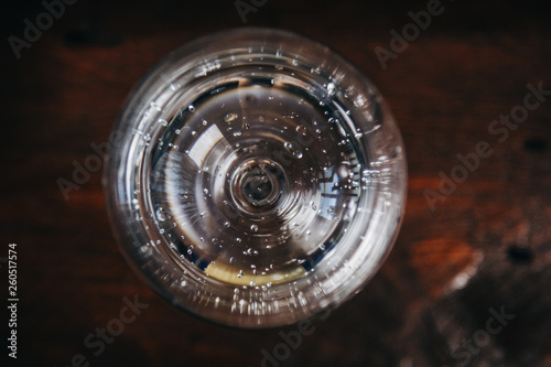 A glass of white wine on a rustic wooden red background. rest, holiday, party. crystal glass closeup. copy space. top view