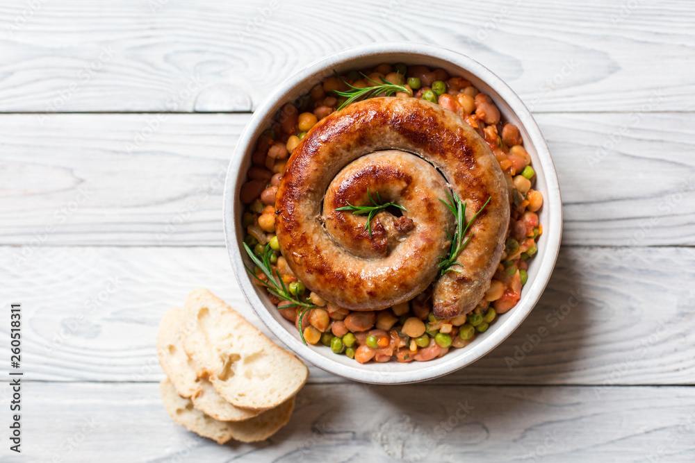 Italian sausage - salsiccia fresca, with bean stew and rosemary on a white background