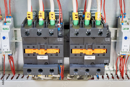 Electrical cables and wires are connected to two powerful magnetic starter or contactor. On the sides of the modular time relay with adjustment. Electrical equipment in the electrical Cabinet.