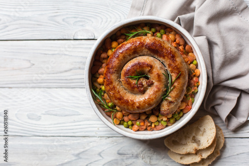 Italian sausage - salsiccia fresca, with bean stew and rosemary on a white background photo