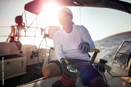 Attractive strong woman sailing with her boat