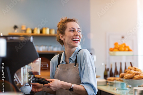 Leinwand Poster Female barista making coffee