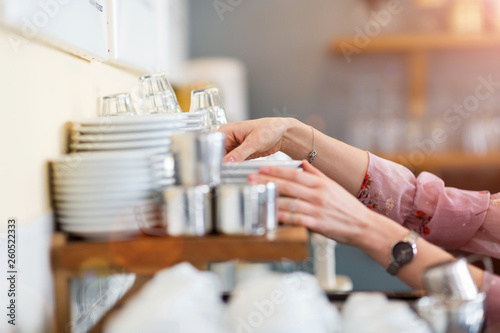 Close up of woman putting clean dishes to dry