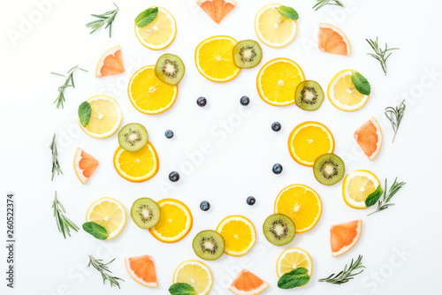 Flat lay with cut fruits and rosemary on white surface
